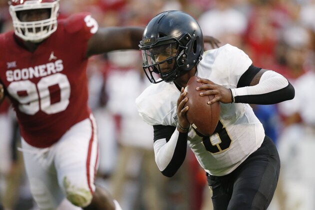 Army quarterback Kelvin Hopkins Jr. (8) carries past Oklahoma defensive lineman Neville Gallimore (90) in the first of an NCAA college football game in Norman, Okla., Saturday, Sept. 22, 2018. (AP Photo/Sue Ogrocki)