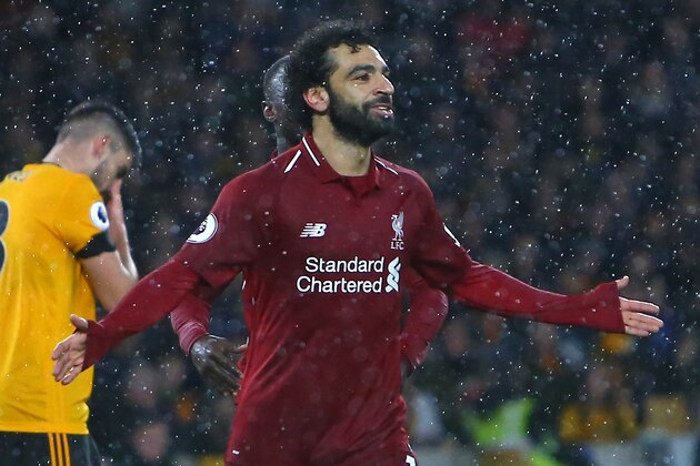 Liverpool's Egyptian midfielder Mohamed Salah celebrates after scoring the opening goal of the English Premier League football match between Wolverhampton Wanderers and Liverpool at the Molineux stadium in Wolverhampton, central England  on December 21, 2018. (Photo by Geoff CADDICK / AFP) / RESTRICTED TO EDITORIAL USE. No use with unauthorized audio, video, data, fixture lists, club/league logos or 'live' services. Online in-match use limited to 120 images. An additional 40 images may be used in extra time. No video emulation. Social media in-match use limited to 120 images. An additional 40 images may be used in extra time. No use in betting publications, games or single club/league/player publications. /         (Photo credit should read GEOFF CADDICK/AFP/Getty Images)