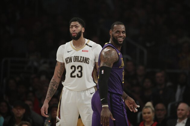 Los Angeles Lakers' LeBron James, right, smiles as he walks past New Orleans Pelicans' Anthony Davis during the first half of an NBA basketball game, Friday, Dec. 21, 2018, in Los Angeles. (AP Photo/Jae C. Hong)