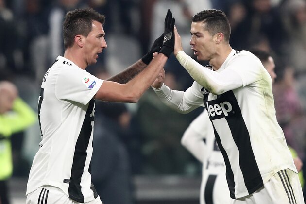 Juventus' Croatian forward Mario Mandzukic (L) celebrates with Juventus' Portuguese forward Cristiano Ronaldo after opening the scoring during the Italian Serie A Football match Juventus FC vs AS Roma on December 22, 2018 at the Juventus stadium in Turin. (Photo by Isabella BONOTTO / AFP)        (Photo credit should read ISABELLA BONOTTO/AFP/Getty Images)