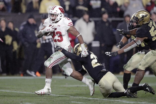 FILE - In this Saturday, Nov. 17, 2018, file photo, Wisconsin running back Jonathan Taylor (23) breaks the tackle of Purdue safety Navon Mosley (27) on his way to scoring a game-winning touchdown during overtime of an NCAA college football game in West Lafayette, Ind. The sophomore is a finalist for a second straight year for the Doak Walker Award, given to the nation’s best running back. He’s 131 yards short of his first 2,000-yard season as the Badgers get ready to play Minnesota this weekend in the annual rivalry game for Paul Bunyan’s Axe. (AP Photo/Michael Conroy, File)