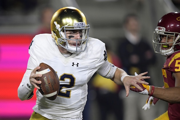 Notre Dame quarterback Ian Book, left, avoids Southern California linebacker Jordan Iosefa during the first half of an NCAA college football game Saturday, Nov. 24, 2018, in Los Angeles. (AP Photo/Mark J. Terrill)