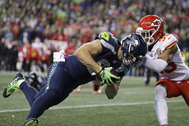 Seattle Seahawks tight end Nick Vannett, left, dives past Kansas City Chiefs cornerback Charvarius Ward, right, for a touchdown during the first half of an NFL football game, Sunday, Dec. 23, 2018, in Seattle. (AP Photo/Elaine Thompson)