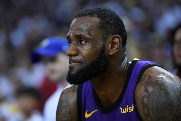 OAKLAND, CA - DECEMBER 25:  LeBron James #23 of the Los Angeles Lakers looks on from the bench after he was hurt against the Golden State Warriors during the second half of their NBA Basketball game at ORACLE Arena on December 25, 2018 in Oakland, California. NOTE TO USER: User expressly acknowledges and agrees that, by downloading and or using this photograph, User is consenting to the terms and conditions of the Getty Images License Agreement.  (Photo by Thearon W. Henderson/Getty Images)