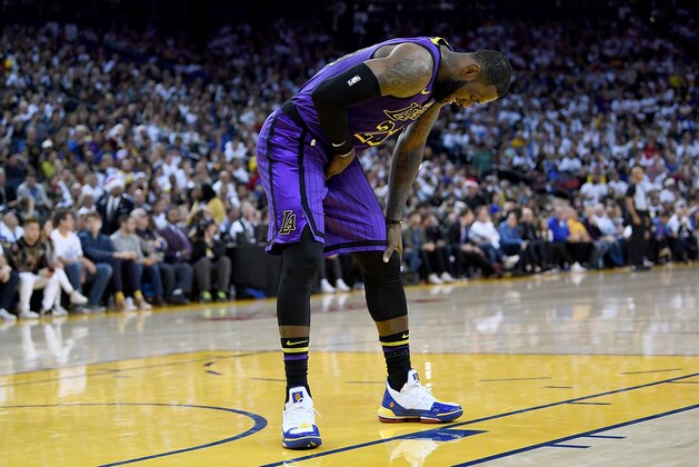 OAKLAND, CA - DECEMBER 25:  LeBron James #23 of the Los Angeles Lakers leans over in pain after he was hurt against the Golden State Warriors during the second half of their NBA Basketball game at ORACLE Arena on December 25, 2018 in Oakland, California. NOTE TO USER: User expressly acknowledges and agrees that, by downloading and or using this photograph, User is consenting to the terms and conditions of the Getty Images License Agreement.  (Photo by Thearon W. Henderson/Getty Images)