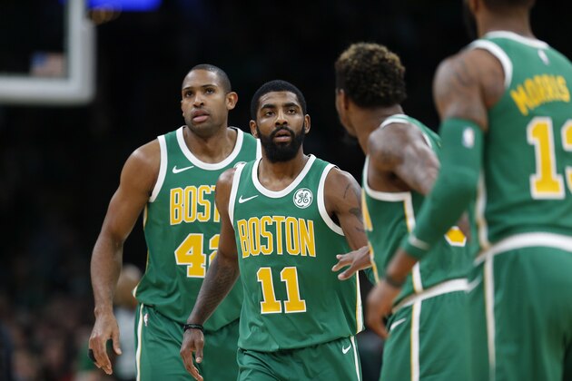 Boston Celtics' Kyrie Irving (11) with teammates, from left, Al Horford, Marcus Smart and Marcus Morris during the second half of an NBA basketball game against the Philadelphia 76ers in Boston, Tuesday, Dec. 25, 2018. (AP Photo/Michael Dwyer)