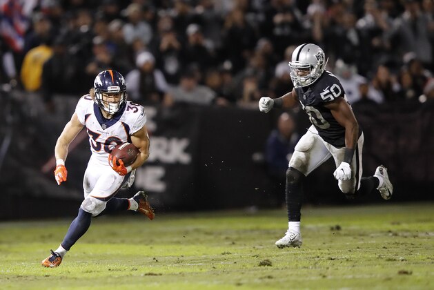 Denver Broncos running back Phillip Lindsay (30) runs past Oakland Raiders linebacker Nicholas Morrow (50) during the first half of an NFL football game in Oakland, Calif., Monday, Dec. 24, 2018. (AP Photo/John Hefti)