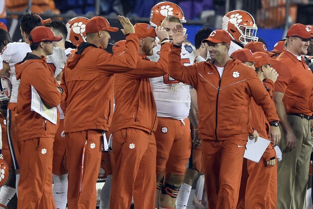 Clemson head coach Dabo Swinney, right, congratulates his coaching staff in the closing seconds of the second half of the Atlantic Coast Conference championship NCAA college football game against Pittsburgh in Charlotte, N.C., Saturday, Dec. 1, 2018. (AP Photo/Mike McCarn)