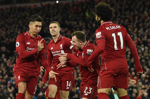 Liverpool's Brazilian midfielder Roberto Firmino (L) celebrates shooting from the penalty spot to score his team's fifth goal during the English Premier League football match between Liverpool and Arsenal at Anfield in Liverpool, north west England on December 29, 2018. (Photo by Paul ELLIS / AFP) / RESTRICTED TO EDITORIAL USE. No use with unauthorized audio, video, data, fixture lists, club/league logos or 'live' services. Online in-match use limited to 120 images. An additional 40 images may be used in extra time. No video emulation. Social media in-match use limited to 120 images. An additional 40 images may be used in extra time. No use in betting publications, games or single club/league/player publications. /         (Photo credit should read PAUL ELLIS/AFP/Getty Images)