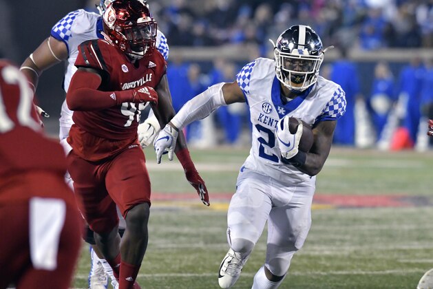 Kentucky running back Benny Snell Jr. (26) runs through an opening in the Louisville defensive line during the first half of an NCAA college football game in Louisville, Ky., Saturday, Nov. 24, 2018. (AP Photo/Timothy D. Easley)