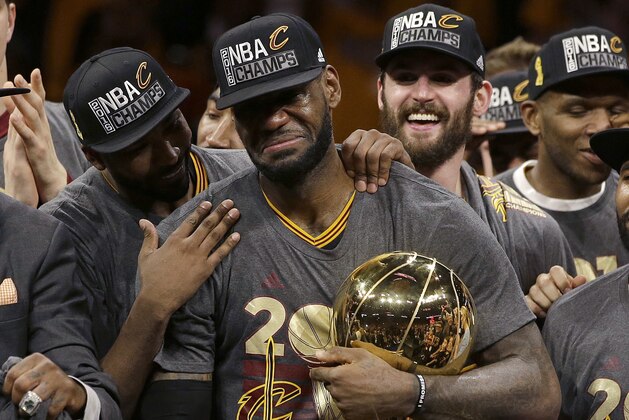 FILE - In this June 19, 2016, file photo, Cleveland Cavaliers forward LeBron James, center, celebrates with teammates, including Kevin Love, third from left, after Game 7 of basketball's NBA Finals against the Golden State Warriors in Oakland, Calif. James delivered on his personal pledge to bring home a title in June. And although it’s one he can never duplicate personally or for a fan base that had its heart broken and healed by him, the Cavaliers’ superstar and his teammates aren’t resting, getting comfortable or complacent. They want more. “We're still pretty much uptight,