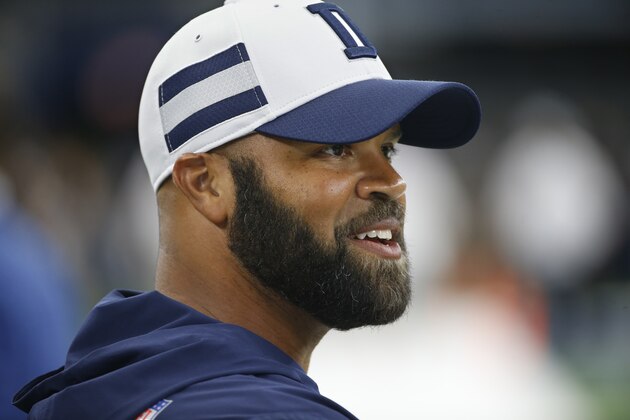 In this Saturday, Aug. 18, 2018, photo, Dallas Cowboys assistant coach Kris Richard walks on the field before an preseason NFL Football game in Arlington, Texas. Richard wears cleats to practice just in case the new secondary coach of the Dallas Cowboys decides to jump in on a play, which he did in training camp. (AP Photo/Ron Jenkins)