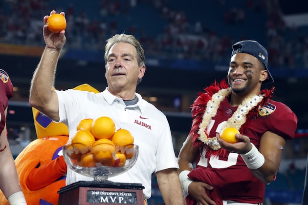 Alabama head coach Nick Saban and quarterback Tua Tagovailoa, throw oranges to the team during the Orange Bowl NCAA college football game trophy presentation, Sunday, Dec. 30, 2018, in Miami Gardens, Fla. Alabama defeated Oklahoma 45-34. (AP Photo/Wilfredo Lee)