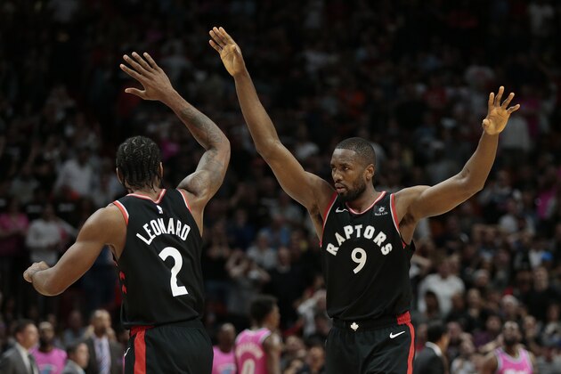 Toronto Raptors forward Serge Ibaka (9) celebrates after his assist on a 3-pointer by Danny Green, with forward Kawhi Leonard (2) in the final minute of an NBA basketball game against the Miami Heat on Wednesday, Dec. 26, 2018, in Miami. Toronto defeated Miami 106-104. (AP Photo/Joel Auerbach)