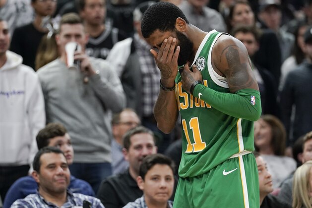 Boston Celtics' Kyrie Irving covers his eye after suffering an injury during the second half of an NBA basketball game against the San Antonio Spurs, Monday, Dec. 31, 2018, in San Antonio. San Antonio won 120-111. (AP Photo/Darren Abate)