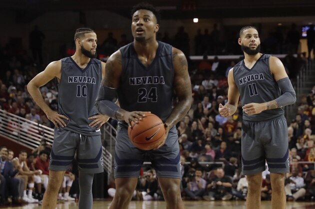 In this Saturday, Dec. 1, 2018 photo, Nevada's Caleb Martin, left, stands next to his twin brother Cody Martin (11) as their teammate Jordan Caroline, center, shoots free throws during the second half of an NCAA college basketball game against Southern California in Los Angeles. No. 6 Nevada has matched its 8-0 start from last season, winning its games by an average of 20 points.(AP Photo/Marcio Jose Sanchez)