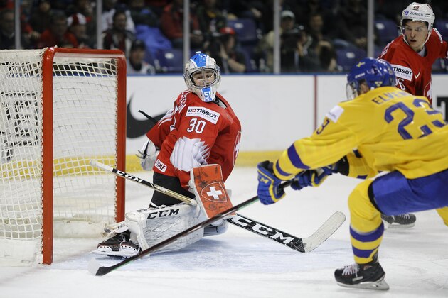 VICTORIA , BC - JANUARY 2:  Luca Hollenstien #30 of Switzerland makes a save on Lucas Elvenes #23 of Sweden during a quarter-final game at the IIHF World Junior Championships at the Save-on-Foods Memorial Centre on January 2, 2019 in Victoria, British Columbia, Canada.  (Photo by Kevin Light/Getty Images)