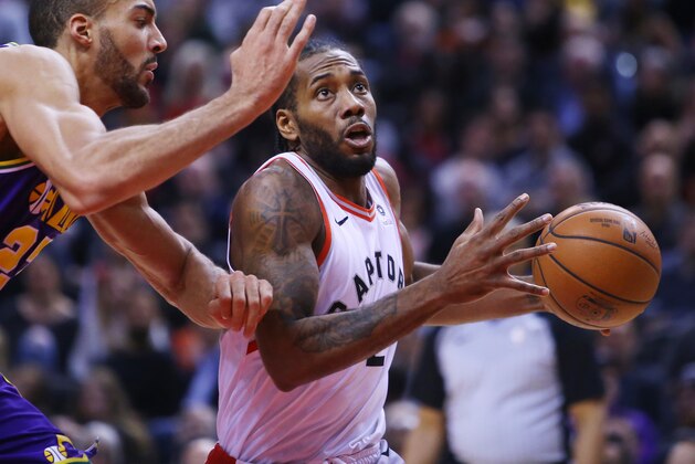 TORONTO, ON - JANUARY 1:  Kawhi Leonard #2 of the Toronto Raptors dribbles the ball as Rudy Gobert #27 of the Utah Jazz defends during the first half of an NBA game at Scotiabank Arena on January 1, 2019 in Toronto, Canada.  NOTE TO USER: User expressly acknowledges and agrees that, by downloading and or using this photograph, User is consenting to the terms and conditions of the Getty Images License Agreement.  (Photo by Vaughn Ridley/Getty Images)