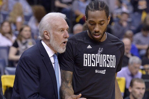 San Antonio Spurs head coach Gregg Popovich, left, talks with San Antonio Spurs forward Kawhi Leonard during the second half of Game 4 in an NBA basketball first-round playoff series against the Memphis Grizzlies Saturday, April 22, 2017, in Memphis, Tenn. (AP Photo/Brandon Dill)
