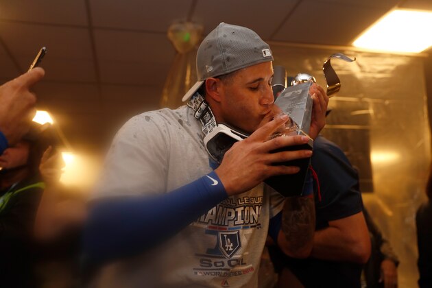 MILWAUKEE, WI - OCTOBER 20:  Manny Machado #8 of the Los Angeles Dodgers celebrates with the Warren C. Giles Trophy in the locker room after defeating the Milwaukee Brewers in Game Seven to win the National League Championship Series at Miller Park on October 20, 2018 in Milwaukee, Wisconsin.  (Photo by Jeff Roberson - Pool/Getty Images)