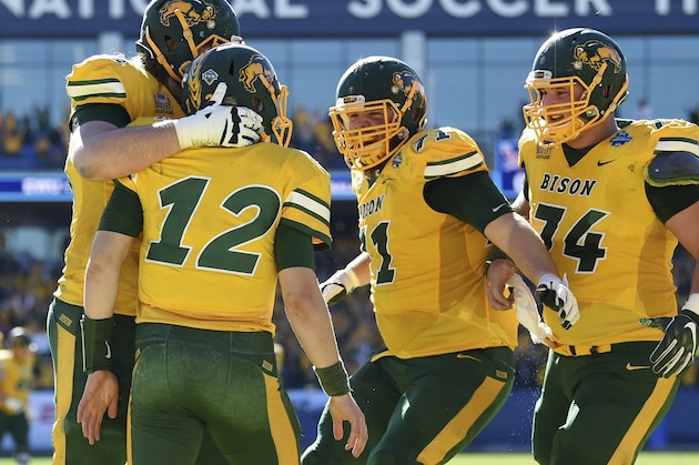 North Dakota State quarterback Easton Stick (12) is congratulated by offensive tackle Zack Johnson, left, offensive guard Luke Bacon (71), and center Tanner Volson (74) after running for a touchdown against Eastern Washington during the first half of the FCS championship NCAA college football game, Saturday, Jan. 5, 2019, in Frisco, Texas. (AP Photo/Jeffrey McWhorter)