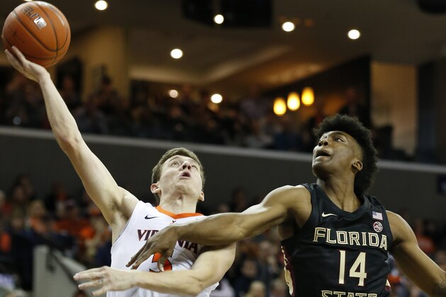 Virginia guard Kyle Guy (5) is fouled as he goes up for a shot against Florida State guard Terance Mann (14) during the first half of an NCAA college basketball game in Charlottesville, Va., Saturday, Jan. 5, 2019. (AP Photo/Steve Helber)
