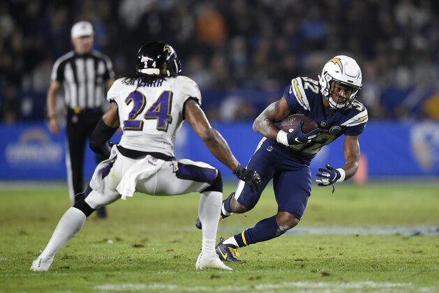 Los Angeles Chargers running back Justin Jackson, right, runs the ball while Baltimore Ravens cornerback Brandon Carr defends during the second half of an NFL football game in Carson, Calif., Sunday, Dec. 23, 2018. (AP Photo/Kelvin Kuo)