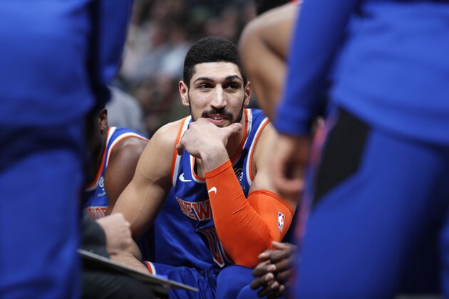 New York Knicks center Enes Kanter jokes with teammates during a timeout the first half of the team's NBA basketball game against the Denver Nuggets on Tuesday, Jan. 1, 2019, in Denver. (AP Photo/David Zalubowski)