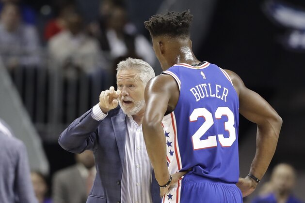 Philadelphia 76ers head coach Brett Brown, left, talks with Jimmy Butler (23) during the first half of an NBA basketball game against the Charlotte Hornets in Charlotte, N.C., Saturday, Nov. 17, 2018. (AP Photo/Chuck Burton)