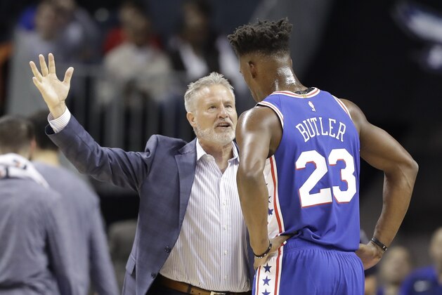 Philadelphia 76ers head coach Brett Brown, left, talks with Jimmy Butler (23) during the first half of an NBA basketball game against the Charlotte Hornets in Charlotte, N.C., Saturday, Nov. 17, 2018. (AP Photo/Chuck Burton)