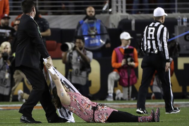 A fan is removed after running on the field during the first half the NCAA college football playoff championship game between Alabama and Clemson, Monday, Jan. 7, 2019, in Santa Clara, Calif. (AP Photo/David J. Phillip)