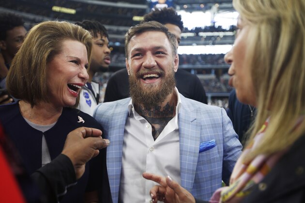 Susan G. Komen for the Cure Founder Nancy Brinker, left, and UFC fighter Conor McGregor are seen on the sidelines before an NFL football game against the Jacksonville Jaguars in Arlington, Texas, Sunday, Oct. 14, 2018. (AP Photo/Jim Cowsert)