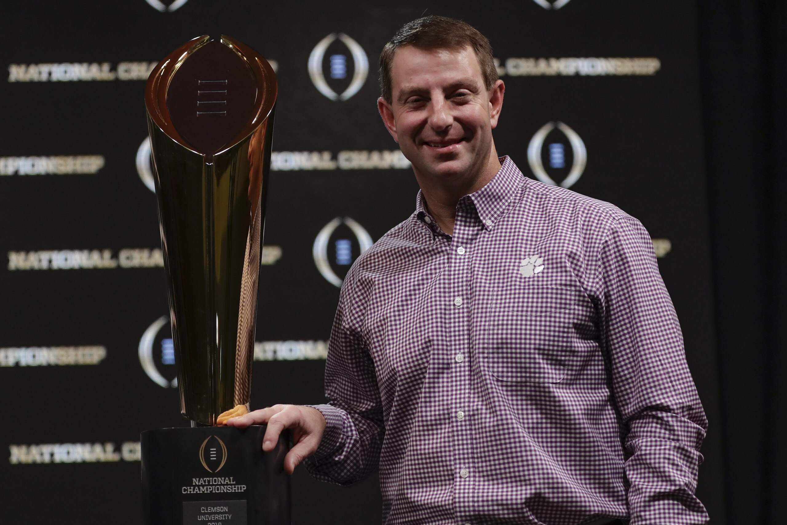 Clemson head coach Dabo Swinney poses with the championship trophy at a news conference for the NCAA college football playoff championship game Tuesday, Jan. 8, 2019, in San Jose, Calif. (AP Photo/David J. Phillip) Clemson head coach Dabo Swinney poses with the championship trophy at a news conference for the NCAA college football playoff championship game Tuesday, Jan. 8, 2019, in San Jose, Calif. (AP Photo/David J. Phillip)