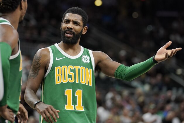Boston Celtics' Kyrie Irving (11) talks to teammate Marcus Smart during the first half of an NBA basketball game against the San Antonio Spurs, Monday, Dec. 31, 2018, in San Antonio. San Antonio won 120-111. (AP Photo/Darren Abate)