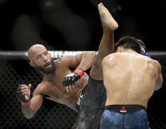 FILE - In this Saturday, Aug. 4, 2018 file photo, Henry Cejudo, right, ducks a kick from Demetrious Johnson during their UFC flyweight title mixed martial arts bout at UFC 227 in Los Angeles. Demetrious Johnson and Eddie Alvarez will make their One Championship debuts at the mixed martial arts promotion’s first show in Japan on March 31. (AP Photo/Chris Carlson, File)