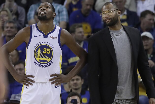 Golden State Warriors forward Kevin Durant (35) stands on the sideline with DeMarcus Cousins during the second half of an NBA basketball game against the Phoenix Suns in Oakland, Calif., Monday, Oct. 22, 2018. (AP Photo/Jeff Chiu)
