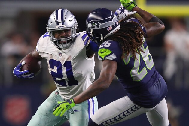 ARLINGTON, TEXAS - JANUARY 05: Ezekiel Elliott #21 of the Dallas Cowboys fights off Shaquill Griffin #26 of the Seattle Seahawks on a run in the fourth quarter during the Wild Card Round at AT&T Stadium on January 05, 2019 in Arlington, Texas. (Photo by Tom Pennington/Getty Images)