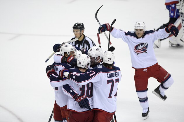 Columbus Blue Jackets right wing Josh Anderson (77), center Boone Jenner (38), and others celebrate after a goal scored by left wing Artemi Panarin (9) during overtime of an NHL hockey game against the Washington Capitals, Saturday, Jan. 12, 2019, in Washington. (AP Photo/Nick Wass)