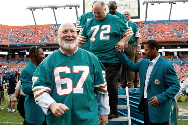 Players from the 1972 Miami Dolphins team, guard Bob Kuechenberg (67) and defensive tackle Bob Heinz (72) walk off the stage following a ceremony honoring the team at a football game against the Baltimore Ravens at Dolphin Stadium in Miami Sunday, Dec. 16, 2007. (AP Photo/Lynne Sladky)