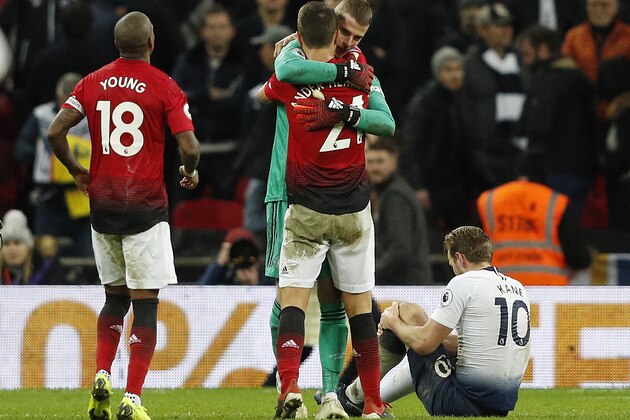 Tottenham Hotspur's English striker Harry Kane (R) holds his leg in pain as players congratulate Manchester United's Spanish goalkeeper David de Gea at the final whistle during the English Premier League football match between Tottenham Hotspur and Manchester United at Wembley Stadium in London, on January 13, 2019. - Manchester United won 1-0. (Photo by Adrian DENNIS / IKIMAGES / AFP) / RESTRICTED TO EDITORIAL USE. No use with unauthorized audio, video, data, fixture lists, club/league logos or 'live' services. Online in-match use limited to 45 images, no video emulation. No use in betting, games or single club/league/player publications.        (Photo credit should read ADRIAN DENNIS/AFP/Getty Images)