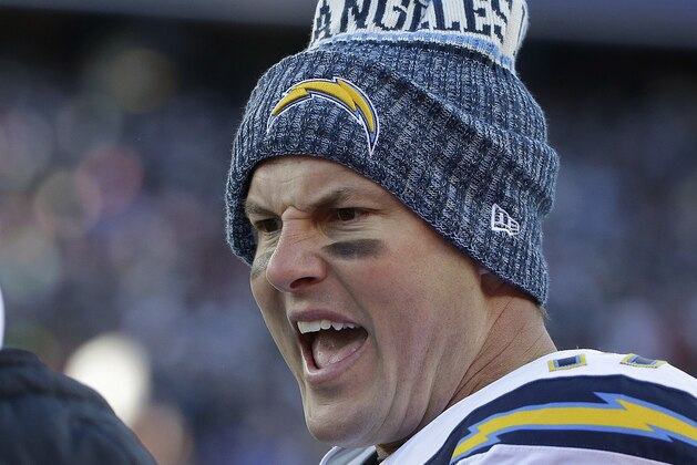 Los Angeles Chargers quarterback Philip Rivers talks to a teammate on the sideline during the first half of an NFL divisional playoff football game against the New England Patriots, Sunday, Jan. 13, 2019, in Foxborough, Mass. (AP Photo/Steven Senne)