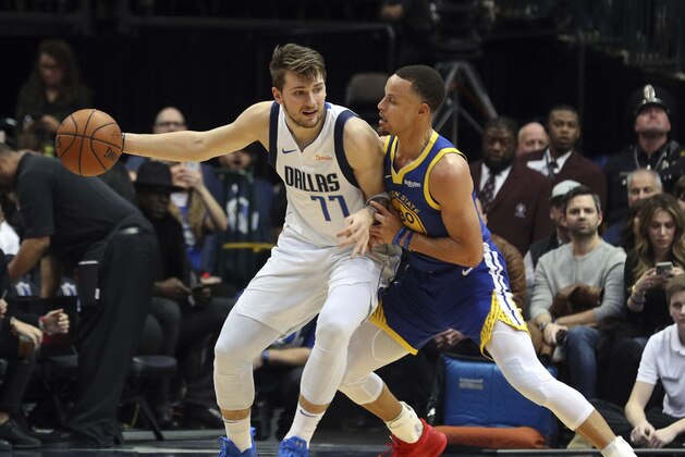 Dallas Mavericks guard Luka Doncic (77) tries to make an opening against Golden State Warriors guard Stephen Curry (30) in the first half of an NBA basketball game Sunday, Jan. 13, 2019, in Dallas. (AP Photo/Richard W. Rodriguez)