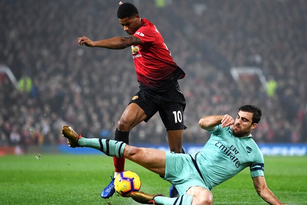 MANCHESTER, ENGLAND - DECEMBER 05:  Sokratis Papastathopoulos of Arsenal tackles Marcus Rashford of Manchester United during the Premier League match between Manchester United and Arsenal FC at Old Trafford on December 5, 2018 in Manchester, United Kingdom.  (Photo by Michael Regan/Getty Images)