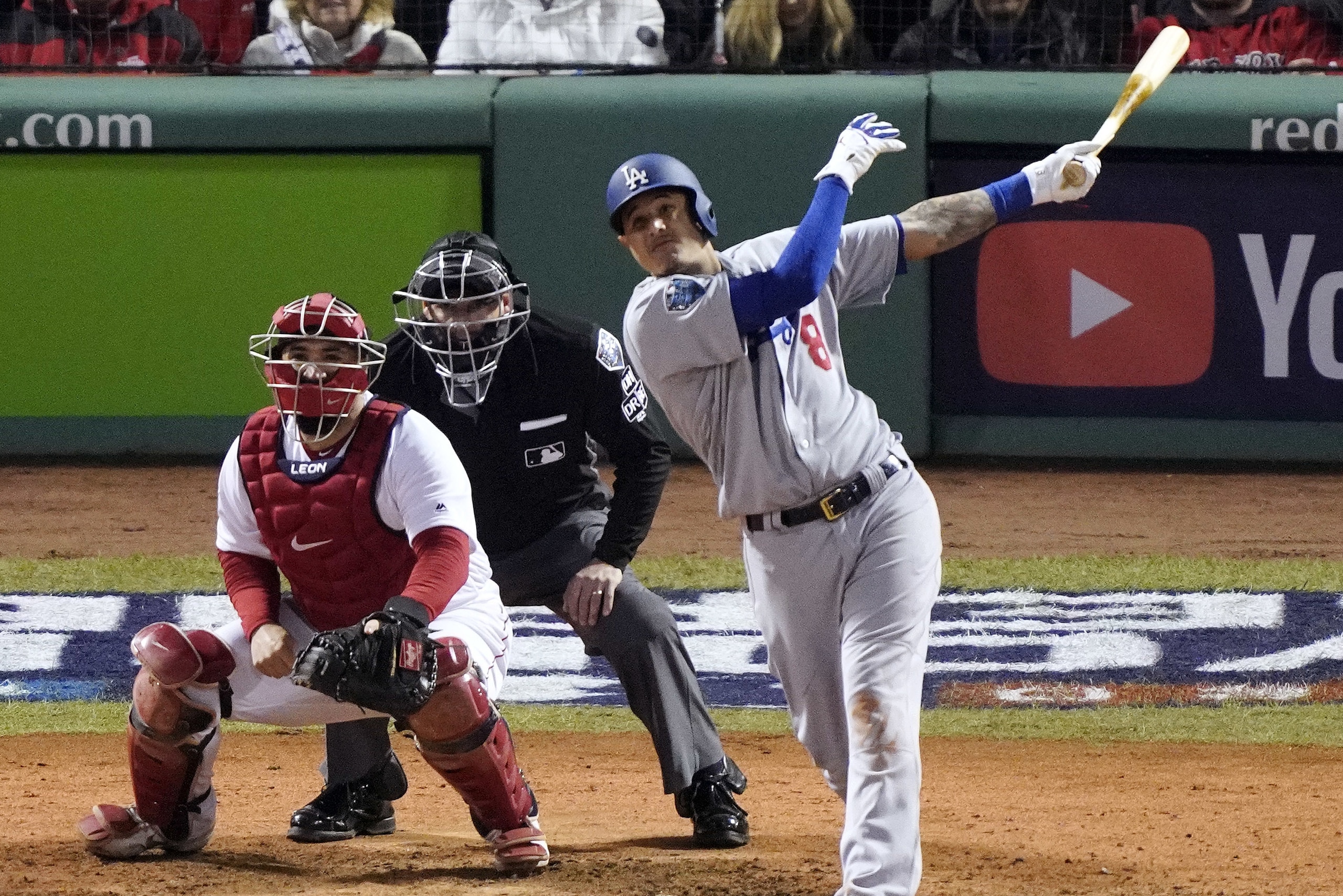 Los Angeles Dodgers' Manny Machado hits a sacrifice fly to drive in Max Muncy during the seventh inning of Game 1 of the World Series baseball game against the Boston Red Sox Tuesday, Oct. 23, 2018, in Boston. (AP Photo/Elise Amendola)