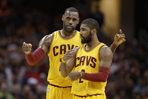 Cleveland Cavaliers' LeBron James, back, talks with Kyrie Irving in the first half of an NBA basketball game against the Orlando Magic, Saturday, Jan. 2, 2016, in Cleveland. (AP Photo/Tony Dejak)