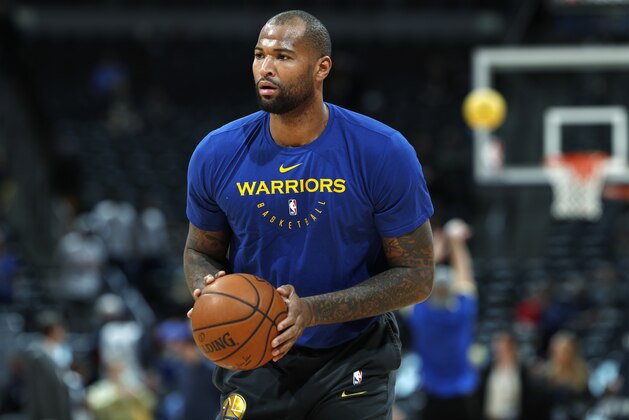 Injured Golden State Warriors center DeMarcus Cousins takes a shot as he works out before the Warriors face the Denver Nuggets in an NBA basketball game, Tuesday, Jan. 15, 2019, in Denver. (AP Photo/David Zalubowski)