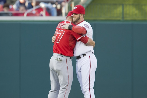 Los Angeles Angels Mike Trout, left, and Washington Nationals Bryce Harper, right, embrace in the outfield before the start of their baseball game, Wednesday, April 23, 2014 in Washington. (AP Photo/Pablo Martinez Monsivais)