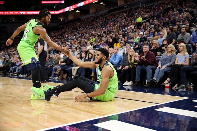 MINNEAPOLIS, MN -  NOVEMBER:  Derrick Rose #25 of the Minnesota Timberwolves helps teammate Karl-Anthony Towns #32 of the Minnesota Timberwolves from the floor during the game against the Denver Nuggets on November 24, 2018 at Target Center in Minneapolis, Minnesota. NOTE TO USER: User expressly acknowledges and agrees that, by downloading and or using this Photograph, user is consenting to the terms and conditions of the Getty Images License Agreement. Mandatory Copyright Notice: Copyright 2018 NBAE (Photo by Jordan Johnson/NBAE via Getty Images)