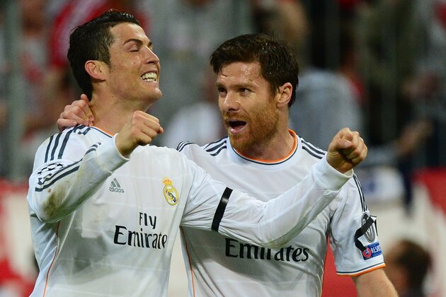 Real Madrid's Portuguese forward Cristiano Ronaldo (L) celebrates scoring the 0-3 with Real Madrid's midfielder Xabi Alonso during the UEFA Champions League second-leg semi-final football match FC Bayern Munich vs Real Madrid CF in Munich, southern Germany, on April 29, 2014. AFP PHOTO / JOHN MACDOUGALL        (Photo credit should read JOHN MACDOUGALL/AFP/Getty Images)