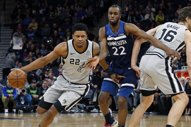 San Antonio Spurs' Rudy Gay, left, drives as Minnesota Timberwolves' Andrew Wiggins, center tries to get around Pau Gasol of Spain in the first half of an NBA basketball game Friday, Jan. 18, 2019, in Minneapolis. (AP Photo/Jim Mone)